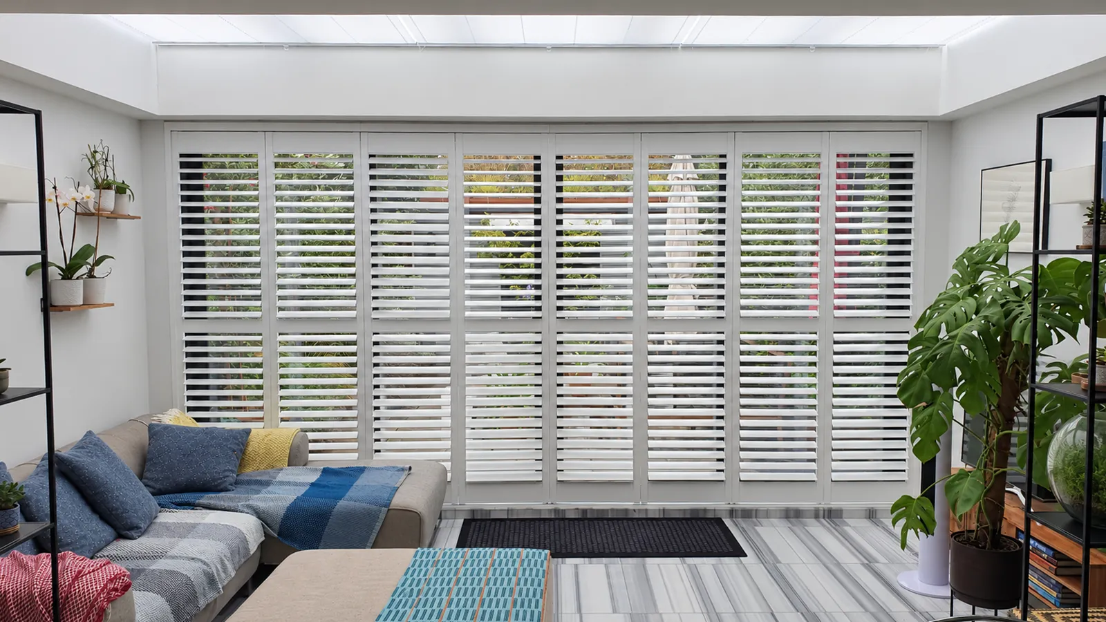 White shutters across a wide patio opening in a living room