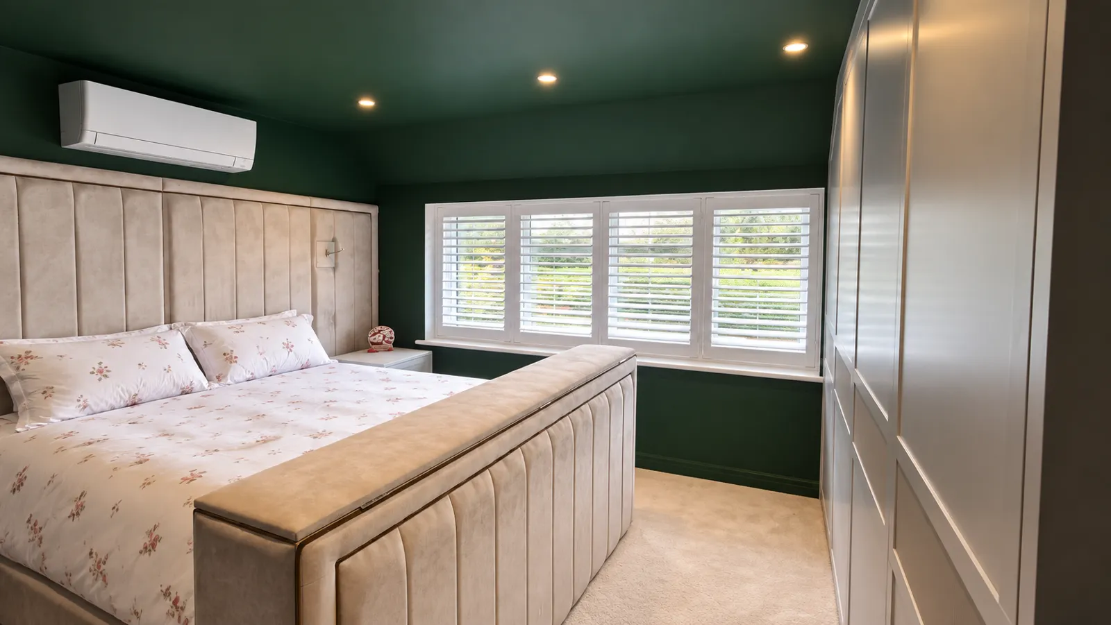 White shutters above a worktop in a green kitchen