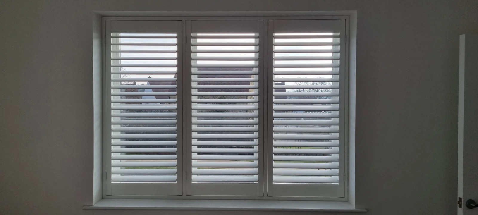 White full-height hardwood shutters at a window in Woodstock
